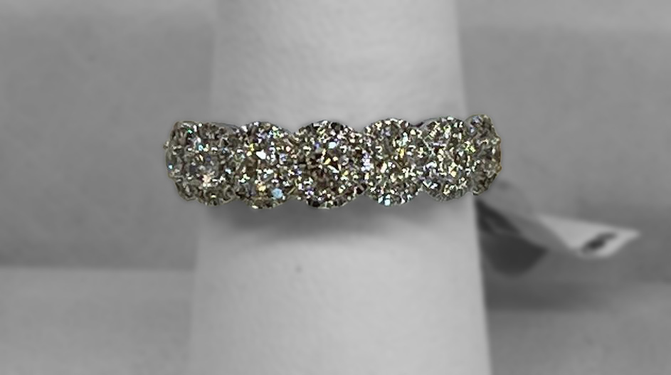 Close up image of a diamond engagement ring with seven dazzling diamonds lined up agains each other in a row across the band
