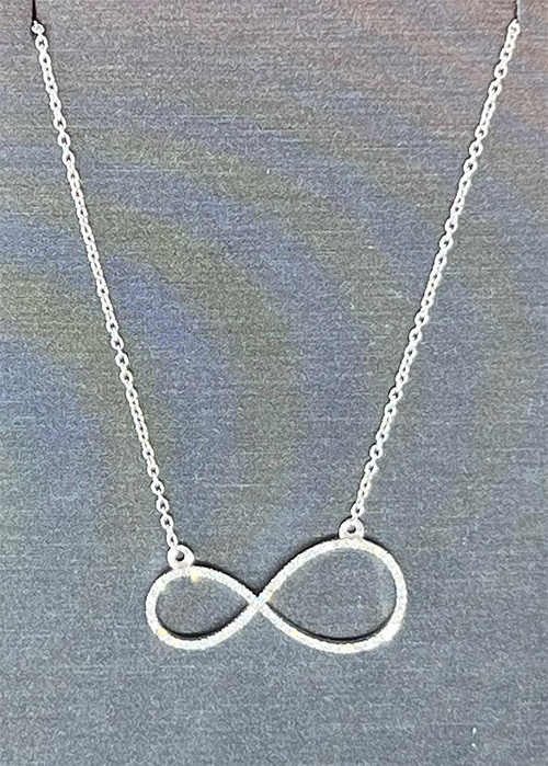 Image of a silver necklace on a gray background. The necklace is two ovals touching together, the symbol for infinity